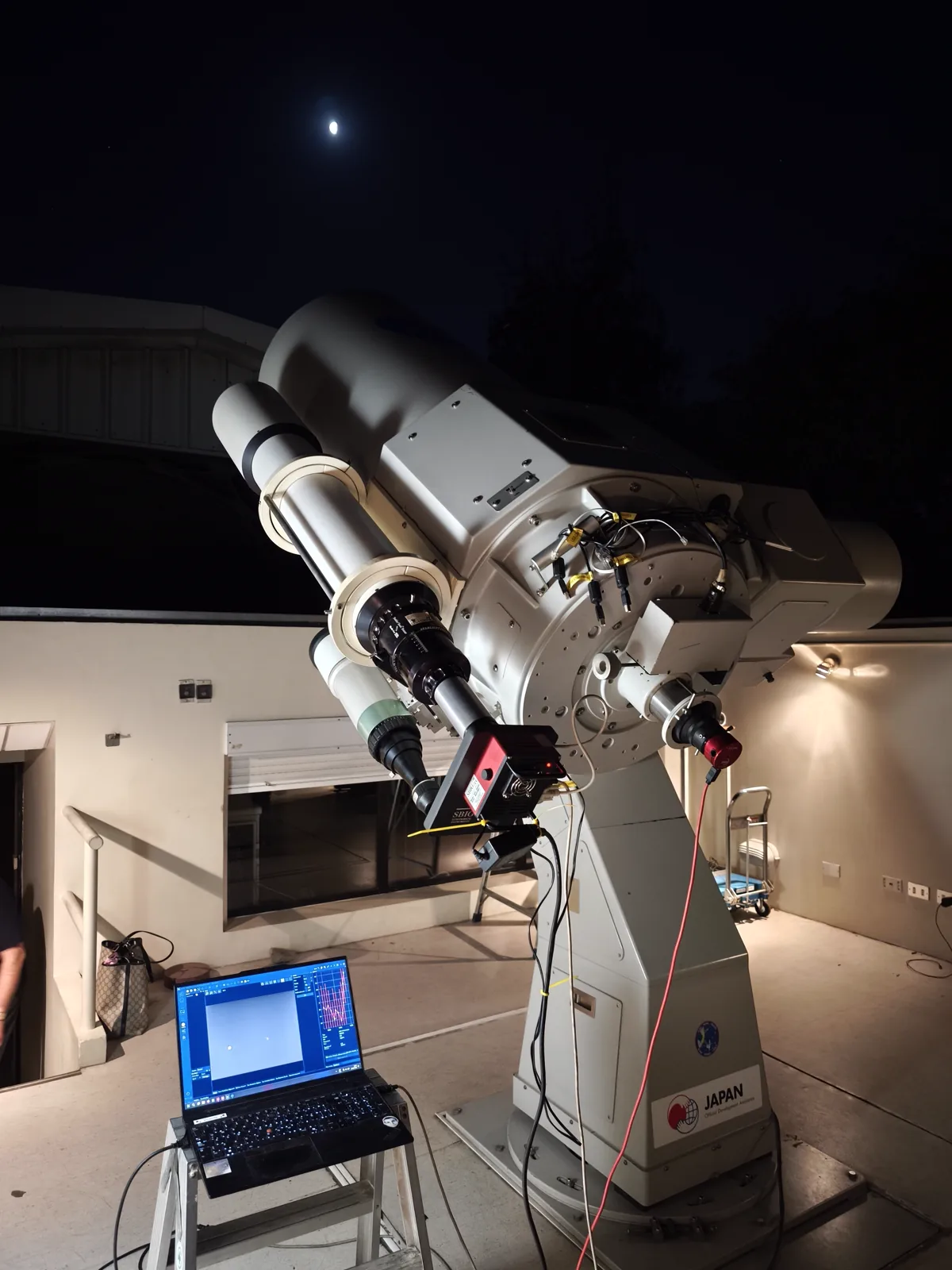 Um telescópio do observatório, sob a Lua